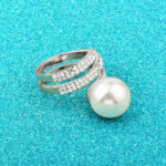 Διακοσμημένο με λευκά ζιργκόν σε κοπή round και μία υπέροχη πέρλα Sea Shell λευκή 12mm​